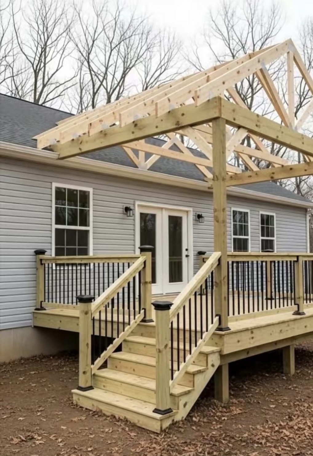 New wooden deck with railing and roof framing under construction