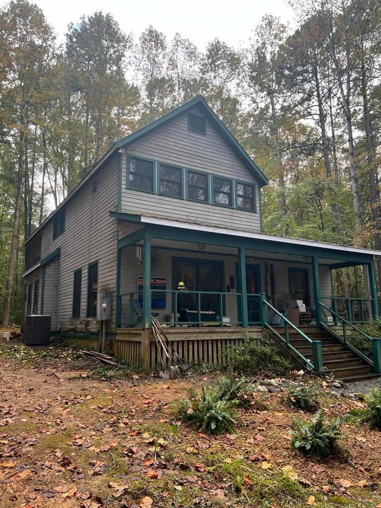 Same home after exterior painting with fresh white siding and navy trim