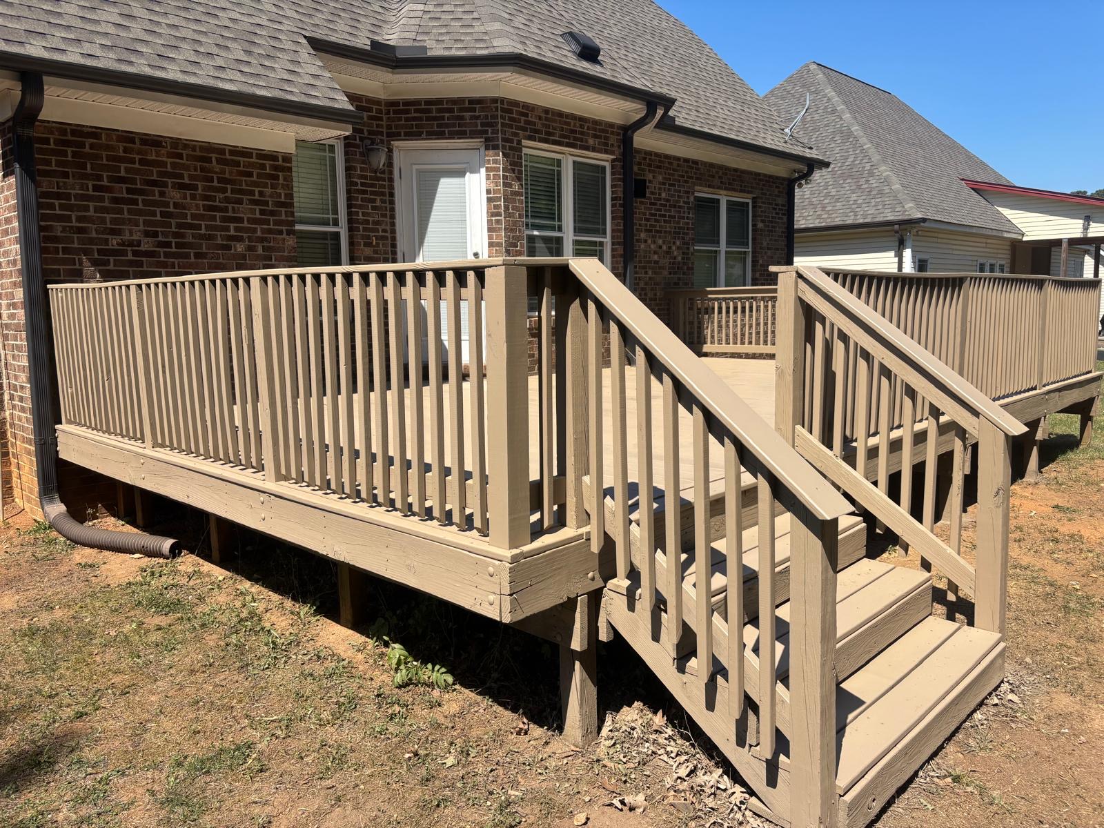 Weathered gray wooden deck with worn railings before refinishing